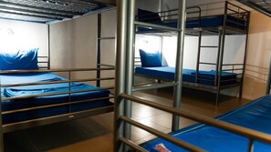 A bunk bed room with metal railings and blue bedding. - Bodega Pool Party Koh Phangan (Ko Pha-ngan)