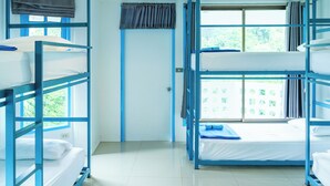 A room with bunk beds, a window with curtains, and a door. - Bodega Pai (Pai)