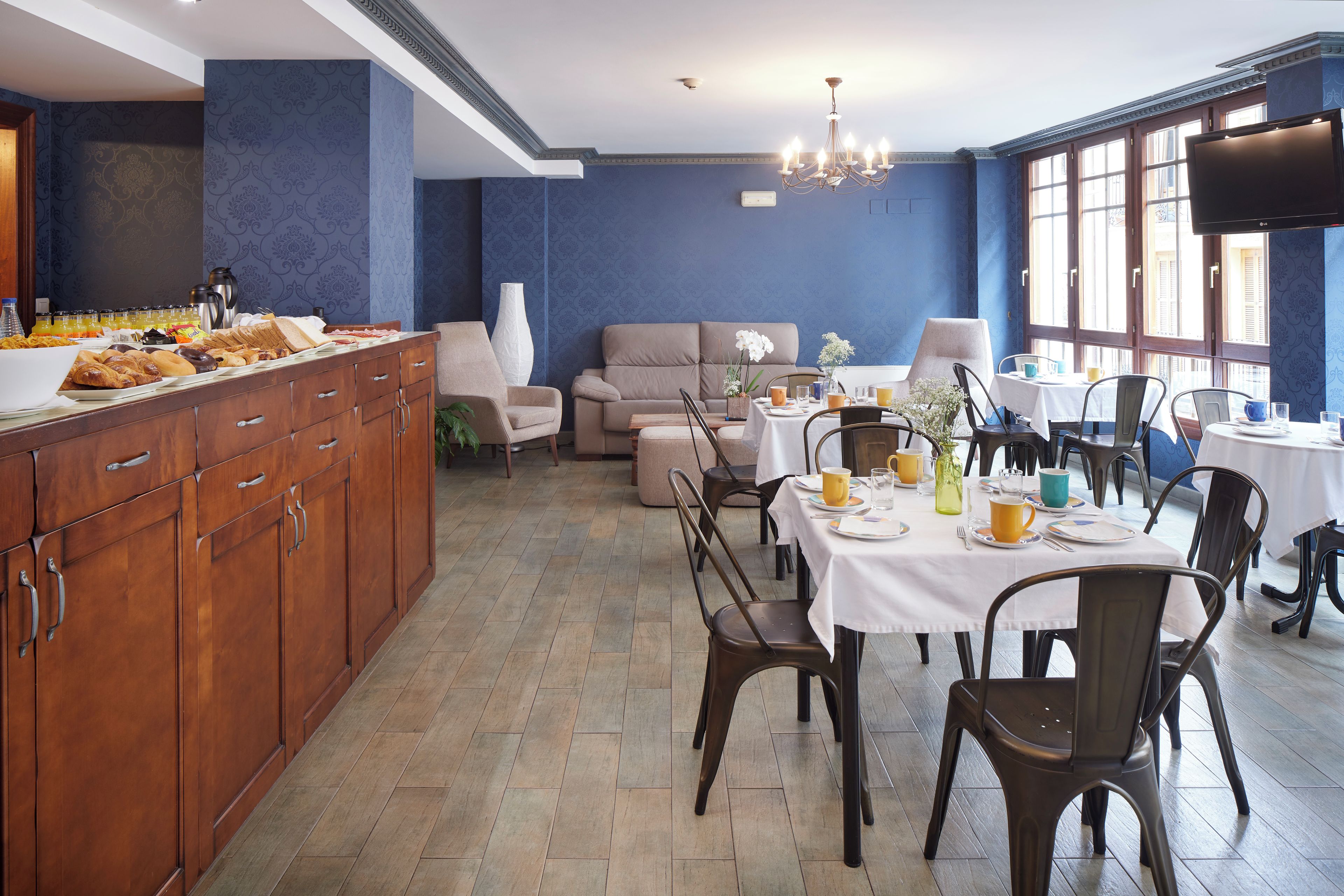 A dining area with a buffet, seating, and a television.