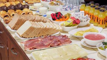 Un bufé con diversos alimentos, incluyendo pan, carnes y salsas.