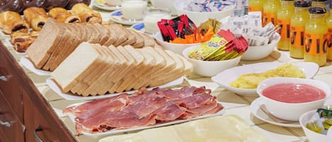 A buffet with various food items including bread, meats, and condiments.