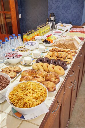 A buffet with various breakfast items including pastries, bread, and beverages. - Iraipe Ongi Hotel (Oñati)