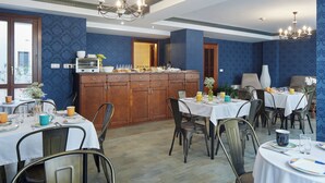 A dining area with multiple tables, chairs, and a central buffet. - Iraipe Ongi Hotel (Oñati)
