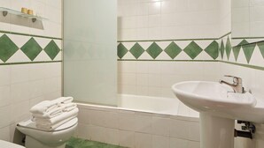 A bathroom with a toilet, sink, and bathtub. - Iraipe Ongi Hotel (Oñati)