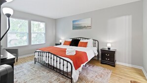 A bedroom with a bed, bedside tables, a desk, and a chair. - Splendid 4 Bed/2.5 Bath- Near Speedway (Indianapolis)