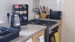 A kitchen with a stove, a coffee maker, and a spice rack. - 2 Bed-Sleeps5-Free Parking-10 min Walk underground (London)