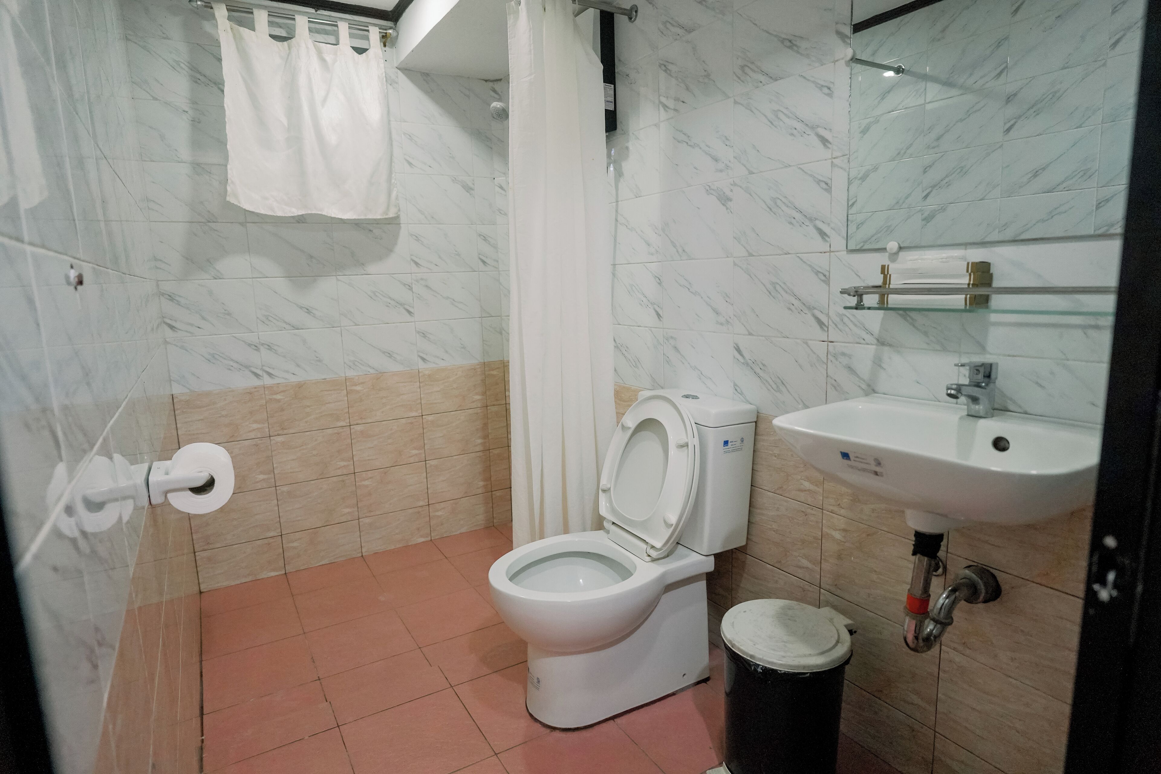 Un baño con inodoro, lavabo y cortina de ducha.