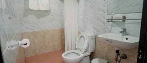 Un baño con inodoro, lavabo y cortina de ducha.