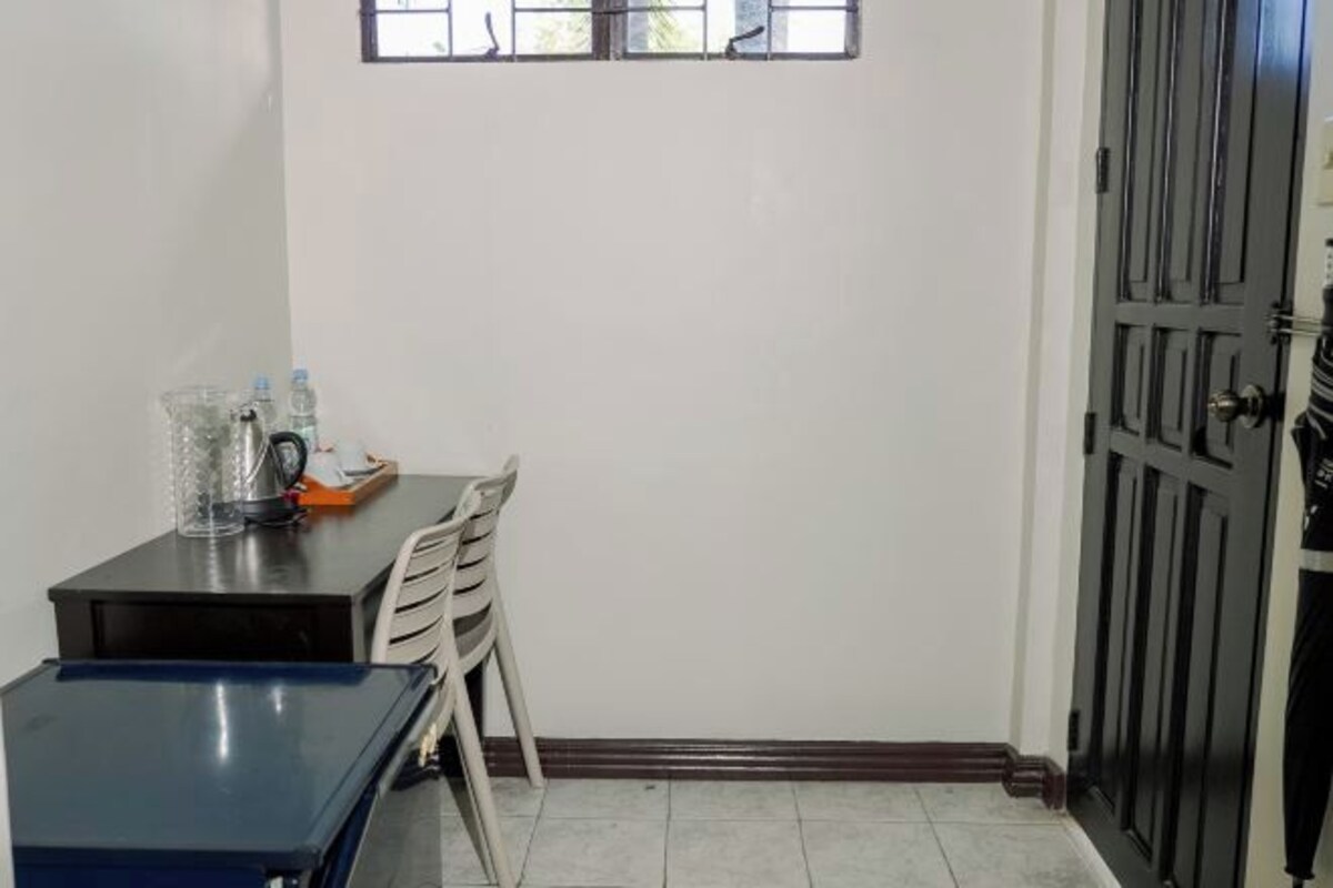 A small room with a table and chairs, a window, and a door.