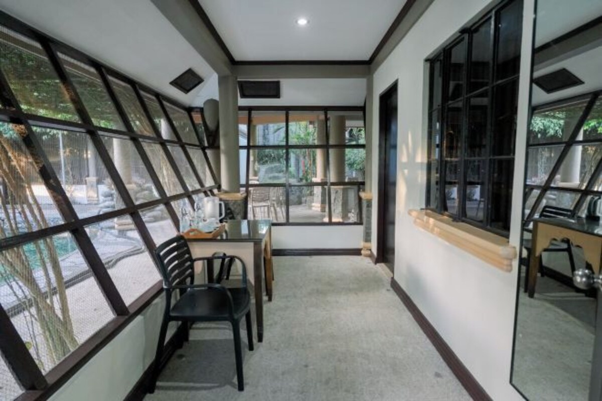 A room with large windows, a dining table, and chairs.