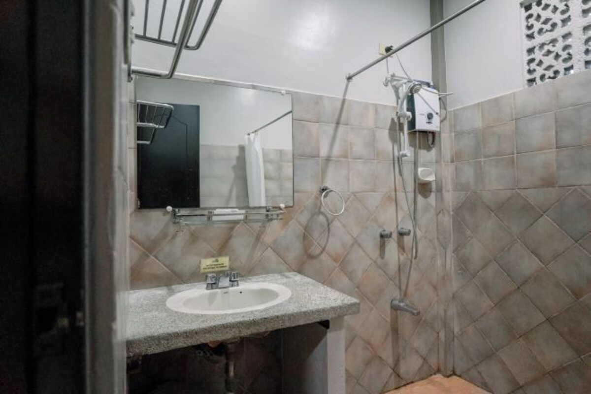 A bathroom with a sink, mirror, and shower.