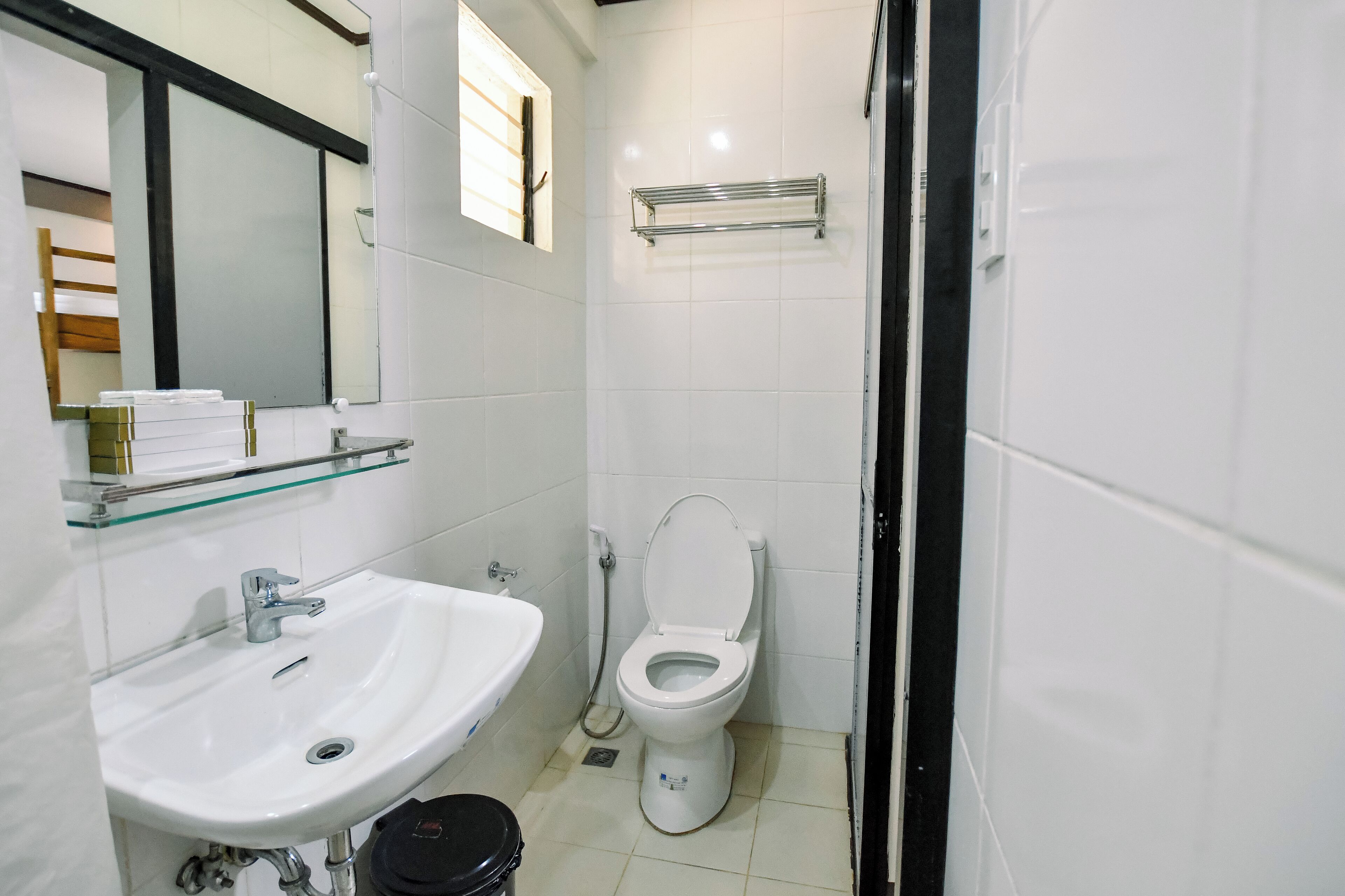 A small, clean bathroom with a white sink, toilet, and mirror.