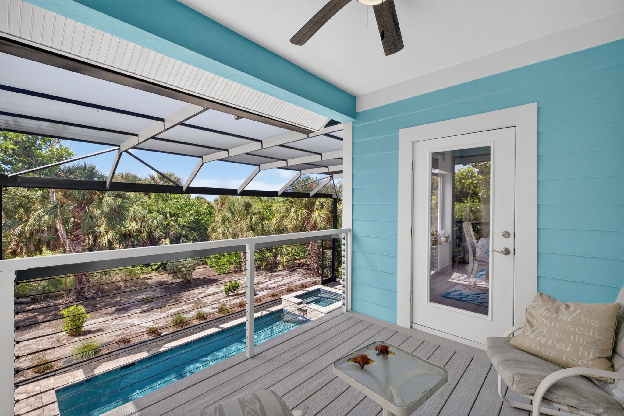 A poolside area with a view of a swimming pool and surrounding greenery.