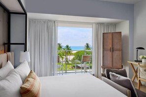 A hotel room with a large bed, a view of the ocean, a balcony with a chair, and a wooden wardrobe. - 2 Connecting Suites at a 4.5⭐️ Hotel (Miami Beach)