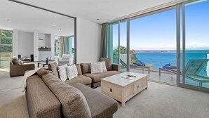 A modern living room with a large window, a sofa set, and a coffee table.