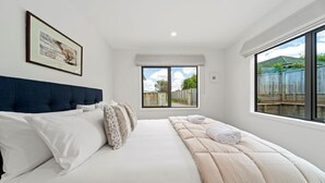 Un dormitorio con una cama grande, una ventana con vistas al exterior y un cuadro enmarcado en la pared.