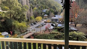 A view of a parking area with cars, a small bridge, and surrounding greenery. - Cosy Mountain retreat in a historic old gold mining town (Walhalla)
