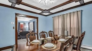 Comedor con mesa de madera, seis sillas y un espejo grande.