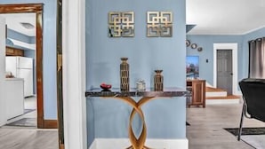 Una cocina moderna con una pared azul de acento, una isla central y detalles decorativos en la pared.
