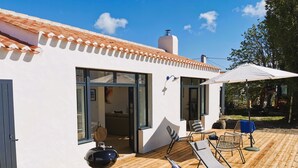 A modern house with a patio, a barbecue grill, and outdoor seating. - Dimitri’s workshop 500m from the beach (Barbâtre)