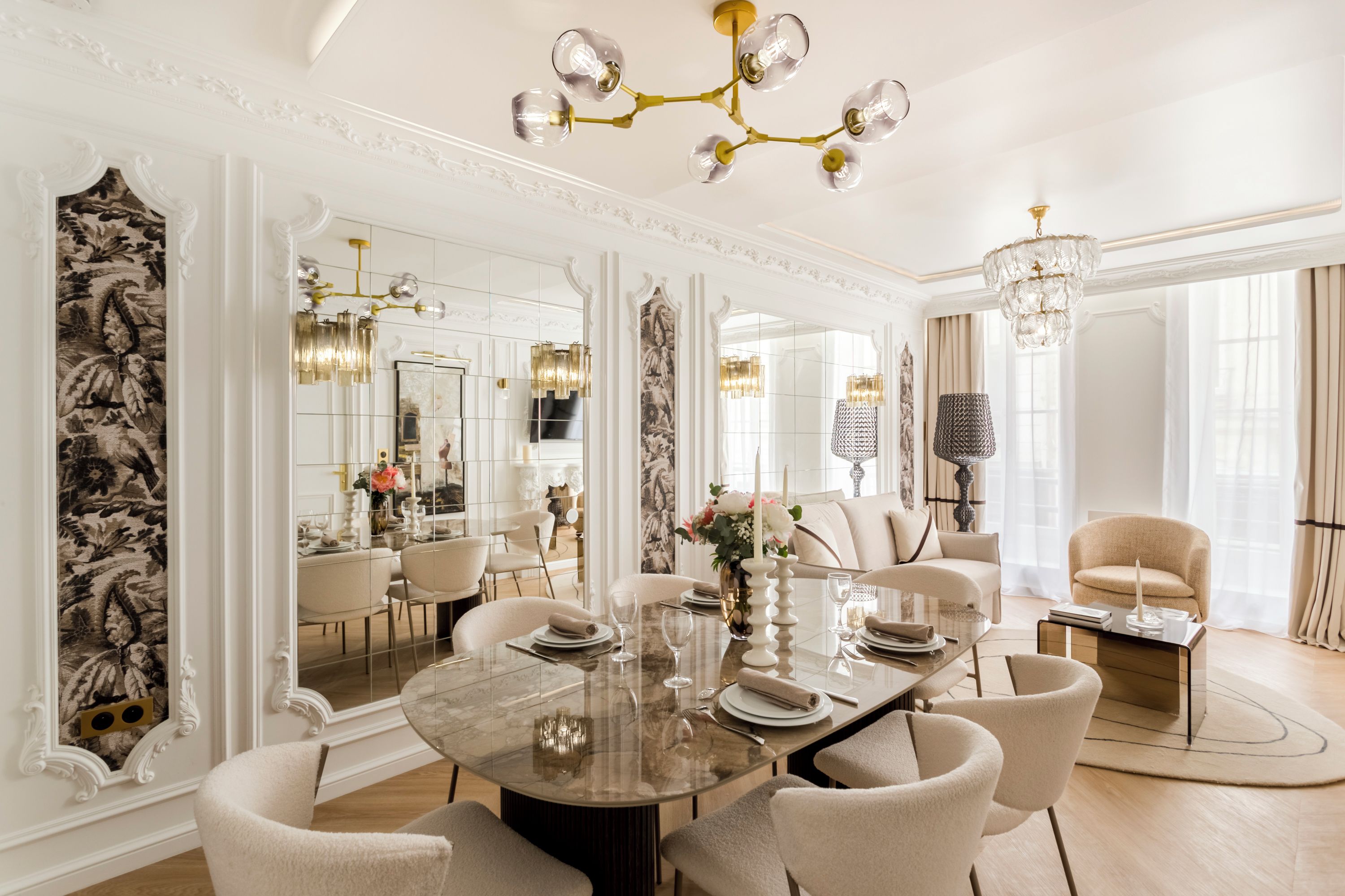 Une salle à manger spacieuse avec une table en marbre, des chaises élégantes et un lustre.