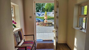 A hallway leading to a door with a view of a parked car and a garden outside. - Stunning 5-Bed Period Home,  Gardens & Tennis Court (Malahide)