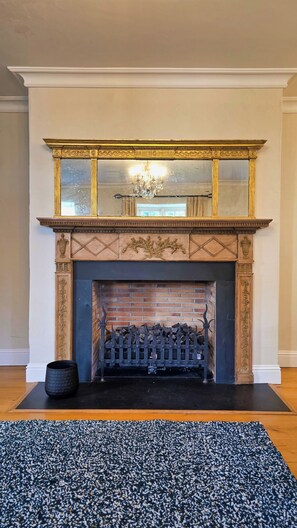 A fireplace with a decorative mantel and a brick wall below. - Stunning 5-Bed Period Home,  Gardens & Tennis Court (Malahide)
