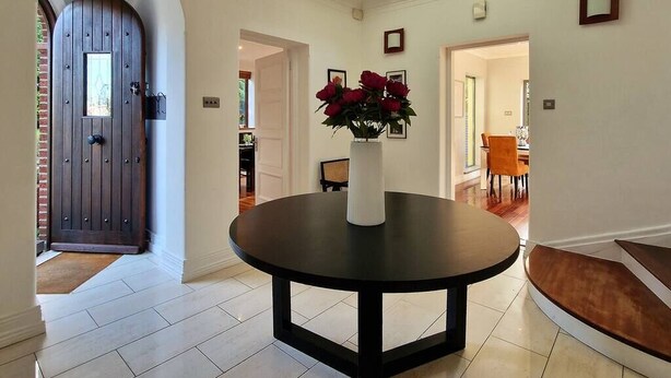 Un intérieur moderne avec une table ronde, une porte en bois foncé et une lucarne.