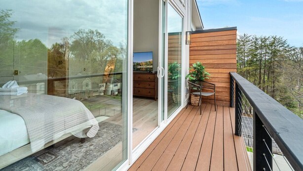 Et moderne soveværelse med en stor glasdør, der fører ud til en balkon.