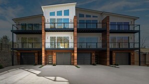 Et moderne, tårnhøjt hus med garage, store vinduer og balkon.