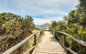 A wooden boardwalk leading to a wooden gazebo by the sea. - Amazing apartment in Rota with WiFi (Rota)