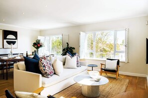 Relax in the spacious living room with a large sofa, coffee table, and dining area.