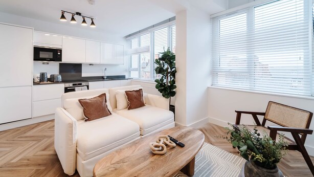 Un appartement moderne comprenant un coin cuisine, un canapé, une table basse et une chaise.