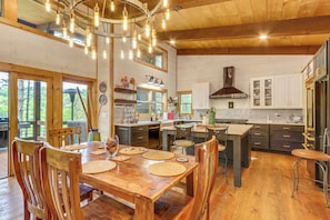Una cocina amplia con armarios de madera, una isla central e iluminación colgante.