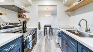 A modern kitchen with a built-in oven, a coffee machine, and a sink with a faucet. - Cozy Couple's Condo! Walk to Old Town Scottsdale (Scottsdale)