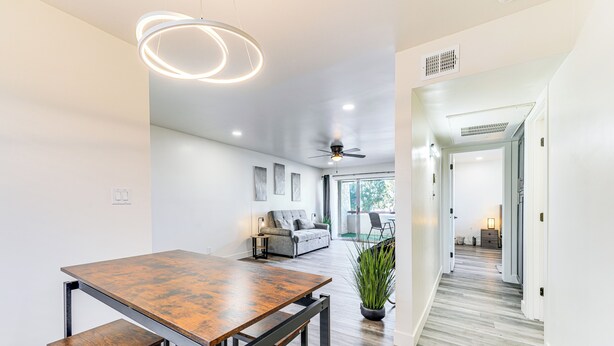 A modern interior with a dining area, a ceiling fan, and a view to a living room. - Cozy Couple's Condo! Walk to Old Town Scottsdale (Scottsdale)