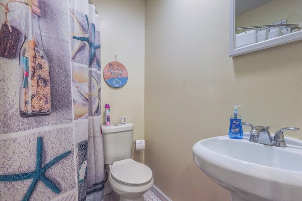 A bathroom with a toilet, sink, and shower curtain with starfish and sea-themed designs. - 2 Mi to Stewart Beach: Galveston Townhome (Galveston)