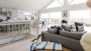 Un espacio habitable amplio con un sofá, una mesa de comedor y una cocina al fondo.