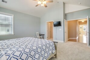 A bedroom with a bed, a ceiling fan, a TV mounted on the wall, and a door leading to another room. - 2 Mi to Rehoboth Beach: Updated Condo w/ Pools (Rehoboth Beach)
