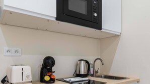 A compact kitchenette with a microwave, toaster, coffee maker, and kettle. - Sous Plex palais des congres Porte Maillot - 4P (Neuilly-sur-Seine)