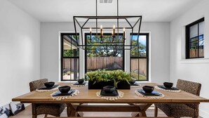 A dining area with a wooden table, black bowls, and woven chairs. - Butterfly:  Luxury w/pool, boat slip, sports court (Kingsland)