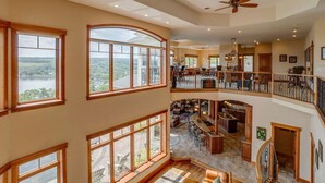 A spacious multi-level home with large windows, a central open-plan living area, and a second-floor balcony. - The Villa: hot tub, sauna, game room, theatre (Keuka Park)