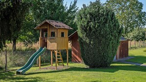 A wooden play structure with a slide and a small house labeled 'Fort Daniel' in a grassy park area. - Holiday Apartment Viola in Schwanau with Private Terrace, Shared Garden and Wi-Fi (Schwanau)