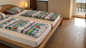 A bedroom with two beds, a window with a view, a ceiling light, and a radiator. - Apartment 'Ferienwohnung Panoramablick' with Mountain View, Shared Terrace and Wi-Fi (Schiltach)