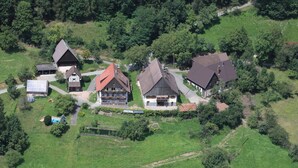 An aerial view of a residential area with houses, green fields, and a small swimming pool. - Apartment 'Ferienwohnung Panoramablick' with Mountain View, Shared Terrace and Wi-Fi (Schiltach)