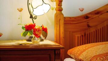 Un comodino in legno con una lampada e un vaso di fiori.