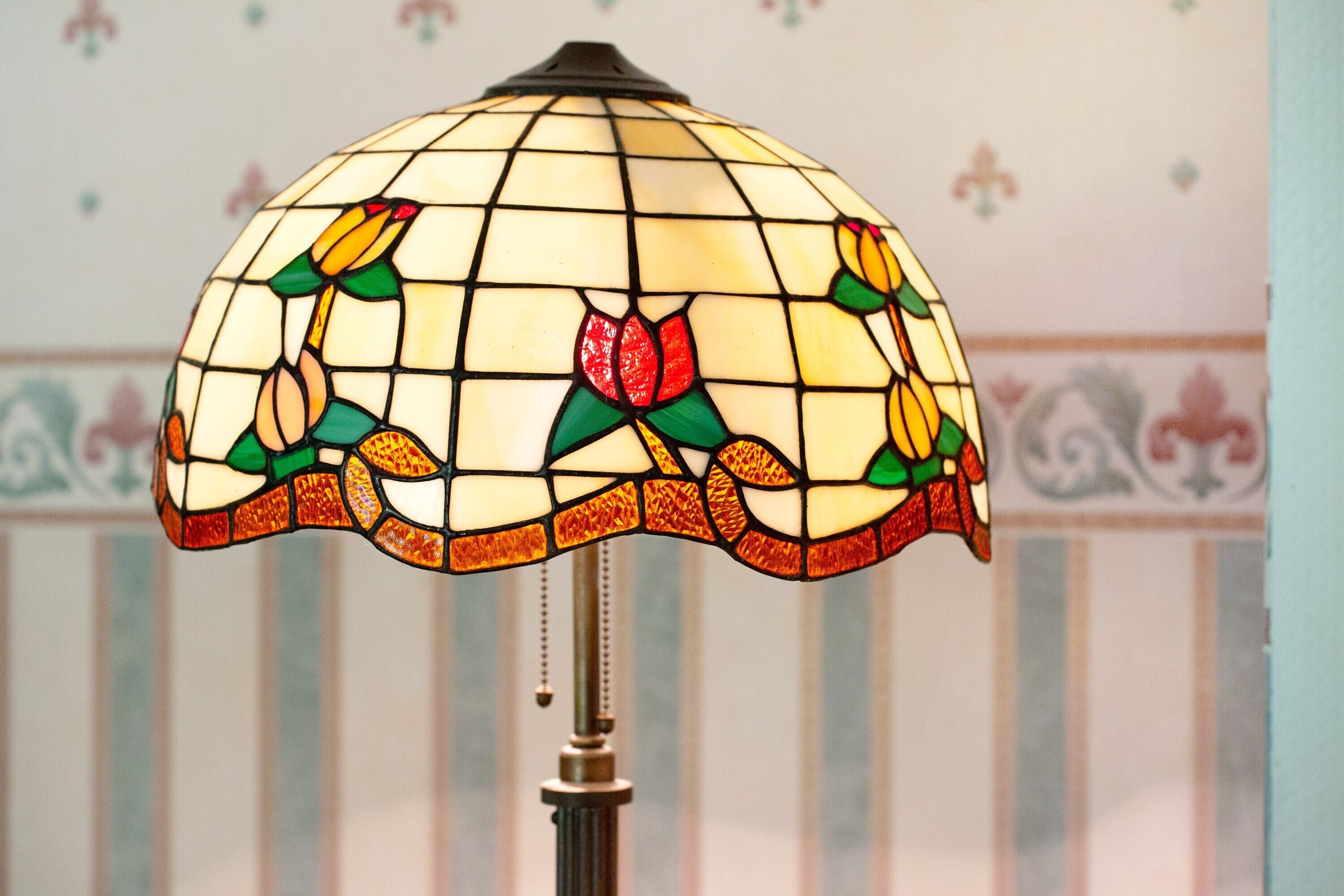 A stained glass lamp shade with floral patterns.