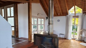 A room with a fireplace, wooden staircase, and large windows. - Holiday Home 'Lichtdurchflutetes Architektenhaus' with Mountain View, Terrace and Wi-Fi (Balingen)