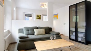 A modern living room with a grey sofa, a wooden coffee table, and a black cabinet with glass doors. - Apartment '1 Mit Seeblick' with Lake View and Wi-Fi (Überlingen)