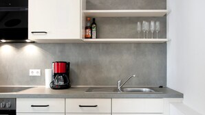 A modern kitchen with a coffee maker, a sink, and a wine glass shelf. - Apartment '1 Mit Seeblick' with Lake View and Wi-Fi (Überlingen)